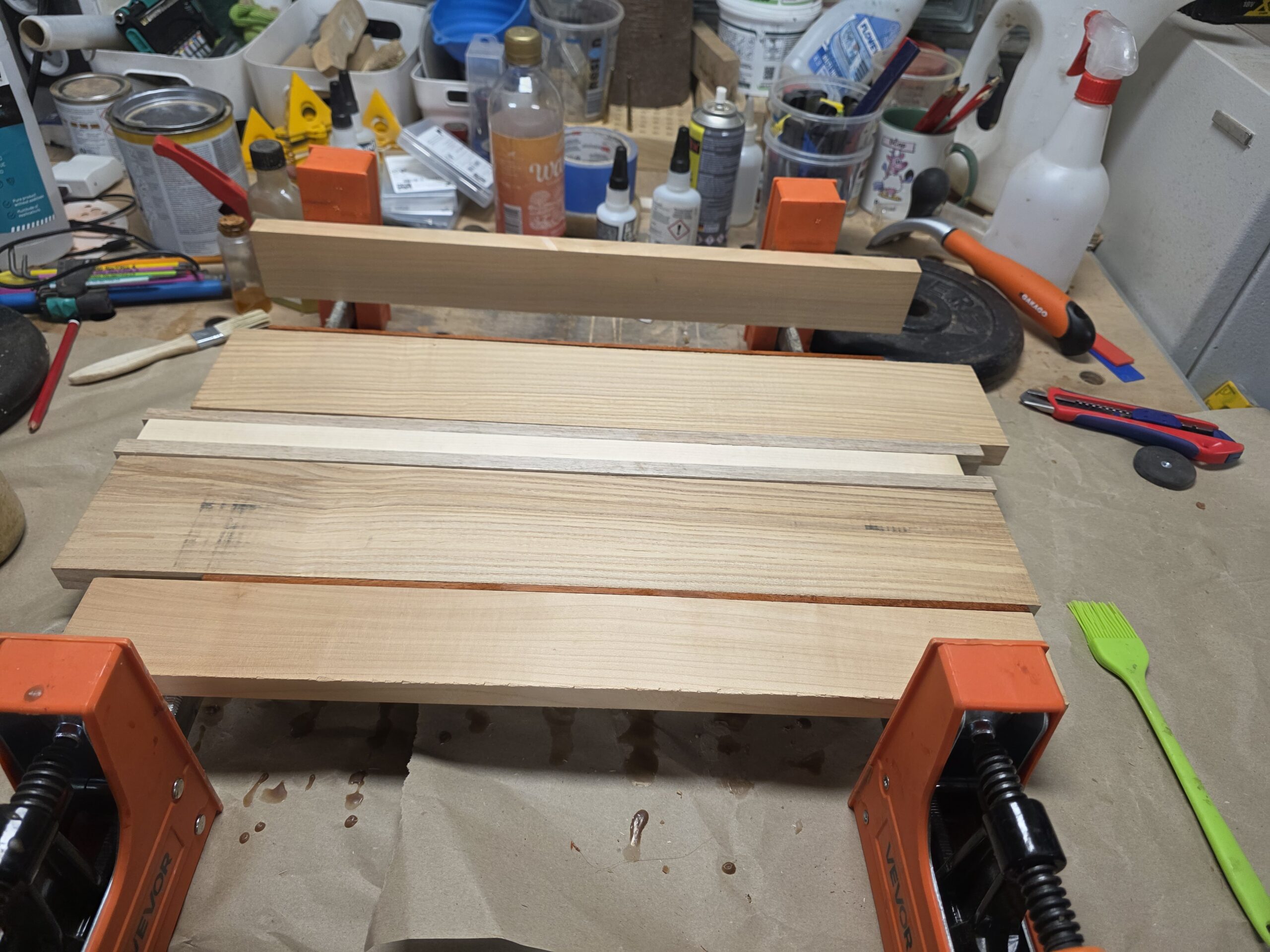 Assemblage des bandes de bois maintenues sous serre-joints dans l’atelier